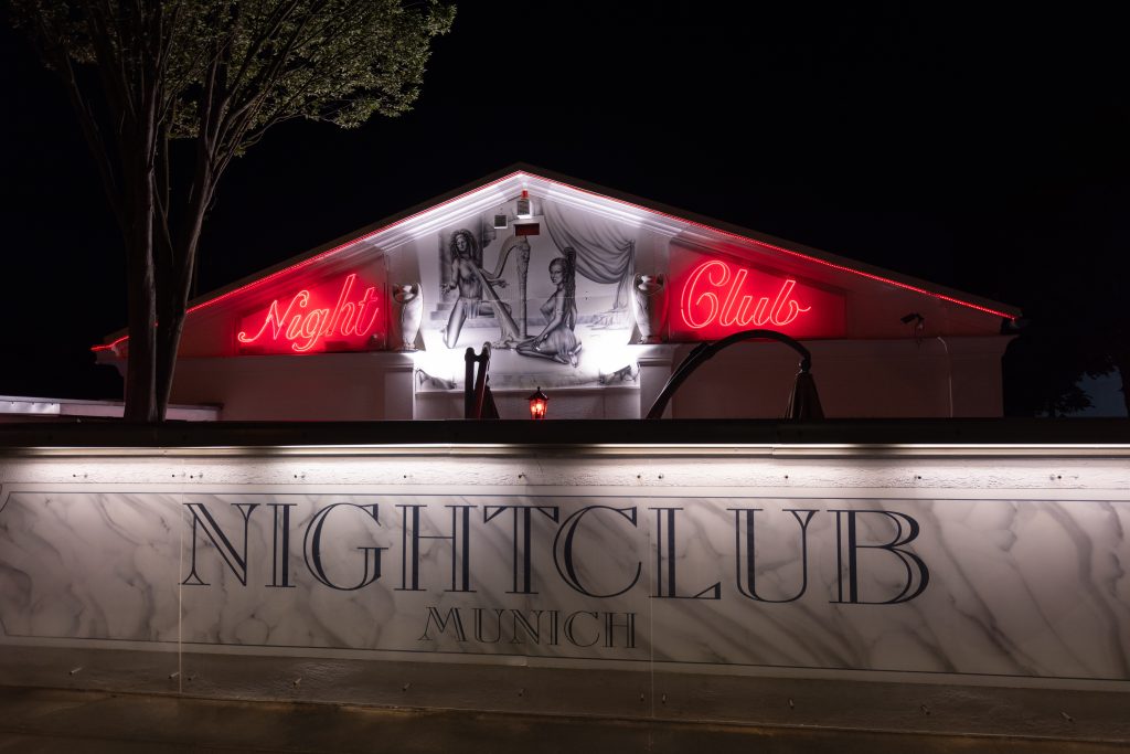 Fassade eines Münchner Nachtclubs bei Nacht mit roter Neonschrift Night Club